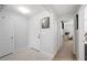 Hallway leading to a study room, featuring a white front door and neutral walls at 283 Lake Lucerne Way, Winter Haven, FL 33881