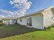 Large backyard with green lawn, sliding glass doors, and patio area at 31 Wagon Cir, Kissimmee, FL 34743
