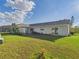 Spacious backyard featuring lush green lawn, mature trees, and patio space at 31 Wagon Cir, Kissimmee, FL 34743