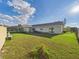 Large backyard with plenty of green space and a partially fenced perimeter at 31 Wagon Cir, Kissimmee, FL 34743