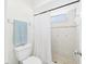 Bright bathroom features a white toilet, shower, shower curtain and window at 31 Wagon Cir, Kissimmee, FL 34743