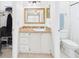 Bathroom features a white sink vanity, decorative mirror, tiled countertop and flooring and toilet at 31 Wagon Cir, Kissimmee, FL 34743