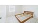 Bright bedroom with a window and a bare wooden bed frame on tile flooring at 31 Wagon Cir, Kissimmee, FL 34743