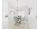 Bright dining room with a modern glass table, gray chairs, and a stylish chandelier at 31 Wagon Cir, Kissimmee, FL 34743