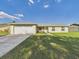 Inviting single-story home with lush lawn, two-car garage, and charming front bench at 31 Wagon Cir, Kissimmee, FL 34743