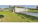 Exterior side view of home with a long driveway leading to an attached garage at 31 Wagon Cir, Kissimmee, FL 34743
