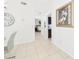 Bright hallway with tile floors leads to a cozy bedroom and a glimpse of the kitchen at 31 Wagon Cir, Kissimmee, FL 34743