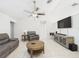 Inviting living room featuring neutral walls, tile floors, modern furnishings, and a ceiling fan at 31 Wagon Cir, Kissimmee, FL 34743