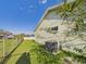 Side yard featuring green lawn, chain link fence, and home's air conditioning unit at 31 Wagon Cir, Kissimmee, FL 34743
