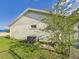 View of the side yard featuring a well-maintained lawn, chain link fence, and air conditioning unit at 31 Wagon Cir, Kissimmee, FL 34743