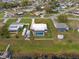 Aerial view of a single-story home featuring a screened-in pool and expansive lawn, with waterfront access to a canal at 326 Canal Dr, Lake Wales, FL 33859