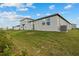 Spacious backyard showcasing a well-manicured lawn, modern home design, and a view of neighboring houses at 3821 Giorgio Dr, Winter Haven, FL 33884