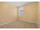 Empty bedroom features neutral walls, beige carpeting and a window at 3821 Giorgio Dr, Winter Haven, FL 33884