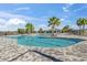 Resort-style community pool featuring palm trees, ample seating, and a refreshing swimming area at 3821 Giorgio Dr, Winter Haven, FL 33884