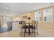 Bright dining area with a round table and chairs, adjacent to kitchen island seating, lit by two windows at 3821 Giorgio Dr, Winter Haven, FL 33884