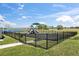 Community playground featuring modern equipment, safety fencing, and a scenic backdrop of a lake at 3821 Giorgio Dr, Winter Haven, FL 33884