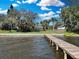 Spacious backyard featuring a private dock extending into the water, surrounded by mature trees at 3943 Chambers St, Lake Wales, FL 33898