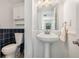 Well-lit bathroom with pedestal sink, tiled accent wall, and ample storage at 3943 Chambers St, Lake Wales, FL 33898