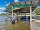 Covered boat lift structure with a tire, providing protection and convenience for watercraft storage and access at 3943 Chambers St, Lake Wales, FL 33898