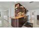 Charming kitchen featuring dark wood cabinets, stone backsplash, and stainless steel appliances at 3943 Chambers St, Lake Wales, FL 33898