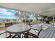 Spacious screened patio with table and chairs, perfect for dining and enjoying the view of the lake and dock at 3943 Chambers St, Lake Wales, FL 33898