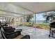 Screened porch featuring chairs, a grill, and a water view with a pier at 3943 Chambers St, Lake Wales, FL 33898