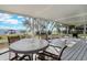 Screened porch featuring a table, chairs, and a water view with a pier at 3943 Chambers St, Lake Wales, FL 33898