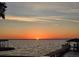 Breathtaking waterfront view of a sunset over the lake with boat dock and a tranquil color palette at 3943 Chambers St, Lake Wales, FL 33898
