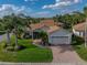 Charming single-story home with lush landscaping, brick walkway, and a two-car garage at 4080 Ashton Club Dr, Lake Wales, FL 33859