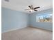 Bedroom with neutral carpet, blue wall and a window overlooking the neighborhood at 4084 Winding Vine Dr, Lakeland, FL 33812