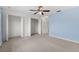 The bedroom features a ceiling fan, neutral carpet, blue walls and two closets at 4084 Winding Vine Dr, Lakeland, FL 33812
