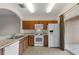 Bright kitchen with wood cabinets, white appliances, and sliding door access to a lanai at 4084 Winding Vine Dr, Lakeland, FL 33812