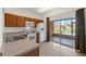 Well-lit kitchen with white appliances, wood cabinets, and sliding door access to screened patio at 4084 Winding Vine Dr, Lakeland, FL 33812