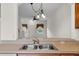 A kitchen sink overlooks into another room with a chandelier at 4084 Winding Vine Dr, Lakeland, FL 33812