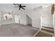 Spacious, carpeted living room with staircase, a ceiling fan, and natural light at 4084 Winding Vine Dr, Lakeland, FL 33812