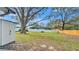 Spacious backyard with a white vinyl fence, mature tree, shed, and plenty of room for activities at 433 Carleton St, Lakeland, FL 33803