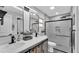 Modern bathroom featuring a double vanity, sleek mirrors, and a walk-in shower with black fixtures and a glass door at 433 Carleton St, Lakeland, FL 33803