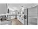 Open kitchen showcases stainless steel appliances, granite countertops, white cabinetry, and wood-look flooring at 433 Carleton St, Lakeland, FL 33803