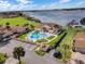 A community pool area featuring lounge chairs, a lake backdrop, lush landscaping, and convenient parking for residents at 4422 Glenns Lndg, Winter Haven, FL 33884