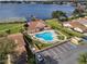 Aerial view of the community pool and clubhouse, featuring lounge chairs and lush landscaping with a serene lake in the background at 4422 Glenns Lndg, Winter Haven, FL 33884