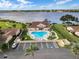 Aerial view showcases the community pool with lounge chairs, lake backdrop, and ample parking, creating a tranquil recreational setting at 4422 Glenns Lndg, Winter Haven, FL 33884