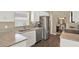Well-lit kitchen featuring stainless steel appliances, light-colored cabinets, granite countertops, and wood-look flooring at 496 Lake Suzanne Dr, Lake Wales, FL 33859