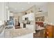 Modern kitchen with granite countertops, stainless steel appliances, white cabinetry, and open access to the living area at 496 Lake Suzanne Dr, Lake Wales, FL 33859