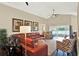 Spacious living room featuring vaulted ceilings, a ceiling fan, a large leather sectional, and lake views at 496 Lake Suzanne Dr, Lake Wales, FL 33859
