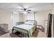 Cozy bedroom with a black metal bed frame, ceiling fan, and neutral decor at 519 Sharon Hill Ct, Winter Haven, FL 33880