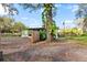 Green house exterior, with a fenced yard, mature tree, and American flag at 519 Sharon Hill Ct, Winter Haven, FL 33880