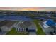Aerial view of a cozy home with a gray roof overlooking a serene pond in the neighborhood at 5767 Lakeside Landings Blvd, Winter Haven, FL 33881