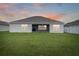 The back exterior of the house shows an outdoor living space, surrounded by well-maintained greenery at 5767 Lakeside Landings Blvd, Winter Haven, FL 33881