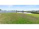 View of backyard with white fence and pond in a residential neighborhood at 5767 Lakeside Landings Blvd, Winter Haven, FL 33881
