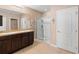This bathroom features a double sink vanity, walk-in shower, and neutral tile flooring at 5767 Lakeside Landings Blvd, Winter Haven, FL 33881